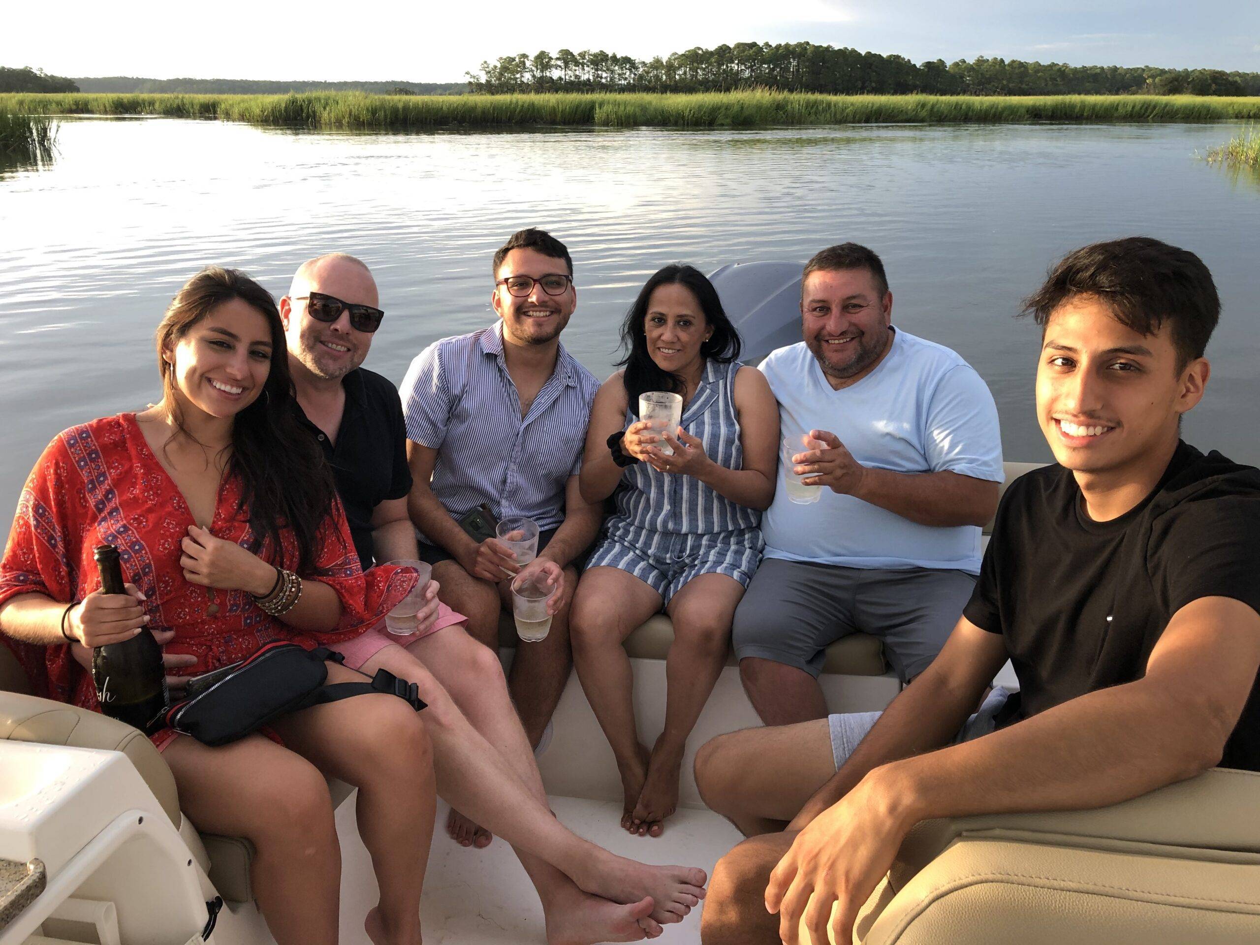 A diverse group of individuals enjoying a leisurely outing on a boat, surrounded by water and nature.