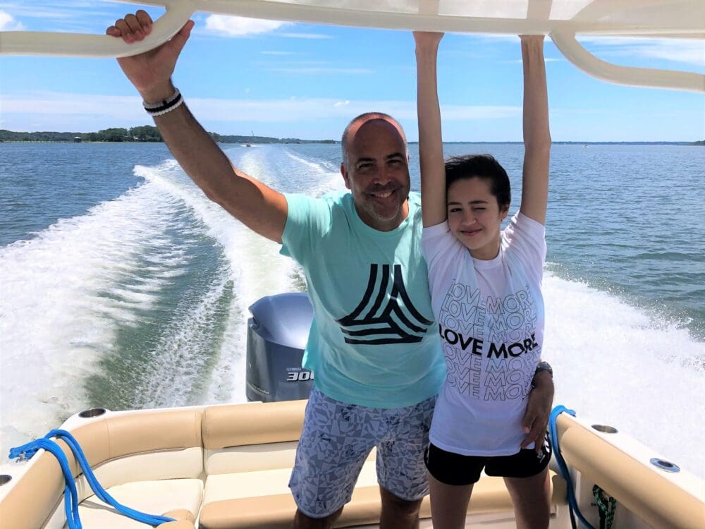 A man and a woman enjoying a serene moment together on a boat, surrounded by calm waters and a clear sky.