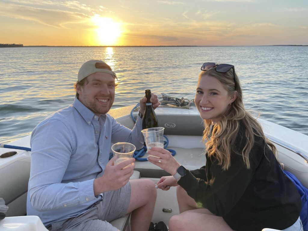 Happy couple toasting a successful proposal on their private sunset cruise