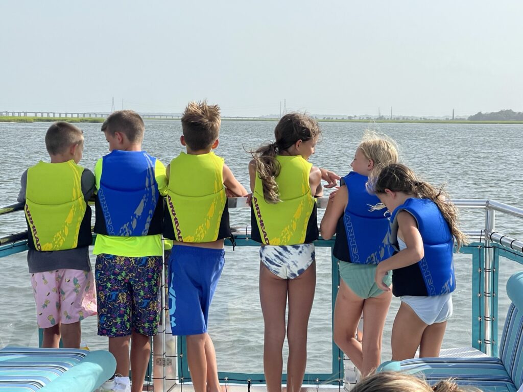 Group of kids having a blast on the bow of the SS Catawampus boat